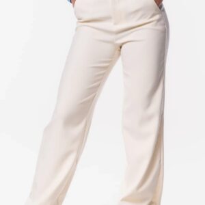 Vrouw draagt de Vs Miss pantalon crème kleur met een blauwe top en bruine boots.