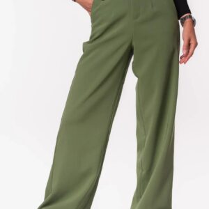 Vrouw draagt een olijfgroene Vs Miss pantalon met wijde pijpen op beige sneakers.