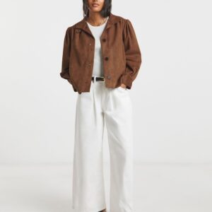 Vrouw in een modieuze bruine suèdelook damesjas met een zachte textuur